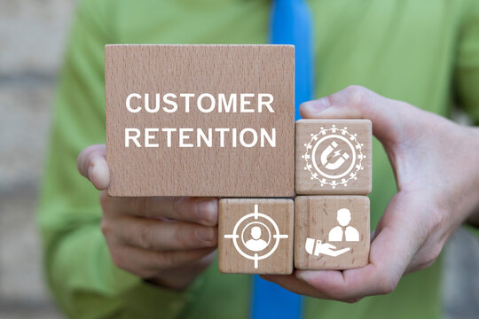 Business man holding wooden blocks with icons and inscription: CUSTOMER RETENTION. Concept of implementing quality assurance practices for customer retention.