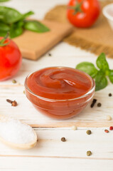 Delicious ketchup with spices and tomatoes on wooden table