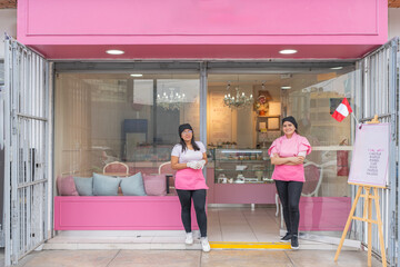 Fototapeta premium Two confident female business owners posing outside their coffee shop