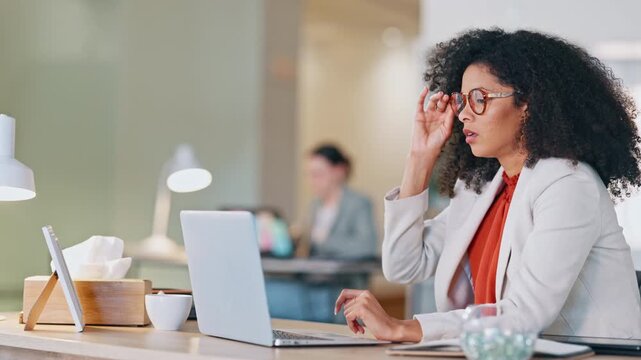 Stressed software analyst typing on laptop with headache and making a mistake while analysing business or company data. Worried professional rubbing forehead with hands while struggling and pressured