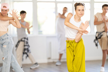 Happy teenagers girls and boy dancing hip hop in dancing class