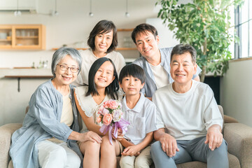 家のソファで家族団欒する三世代家族・ファミリー
