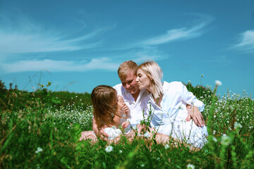 Fototapeta premium Happy family in the garden having fun. enjoyed together in the green garden. Family enjoying sunny fall day in nature