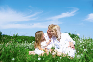 Fototapeta premium Happy family in the garden having fun. enjoyed together in the green garden. Family enjoying sunny fall day in nature