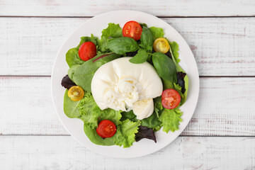 Delicious fresh burrata salad on white wooden table, top view