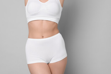 Fototapeta premium Diet and weight loss concept. Woman with slim body against light grey background, closeup. Space for text