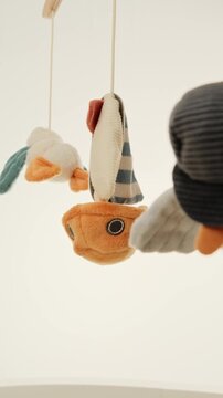 Close up interior shoot of spinning crib mobile mounted on a cot. Baby cot carousel hanging and rotating. Handheld shoot with shallow depth of field.