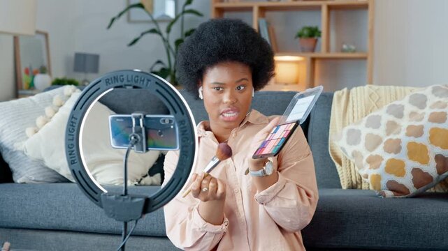 Beauty influencer filming a makeup tutorial at home. Young female blogger live streaming a broadcast online with ring light for a vlog channel. Recording a fun podcast for followers on social media