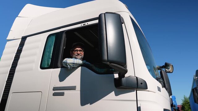 Senior truck driver sitting in cab. Right hand drive car