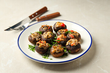 Stuffed mushrooms and cutlery on beige background