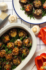 Stuffed mushrooms and vegetables on light background, top view