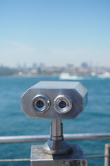 Coin-operated binoculars looking out over city ,