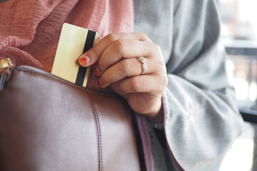 woman taking credit card out from her purse 