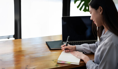 Happy young woman freelancer doing her job sits at co-workspace.