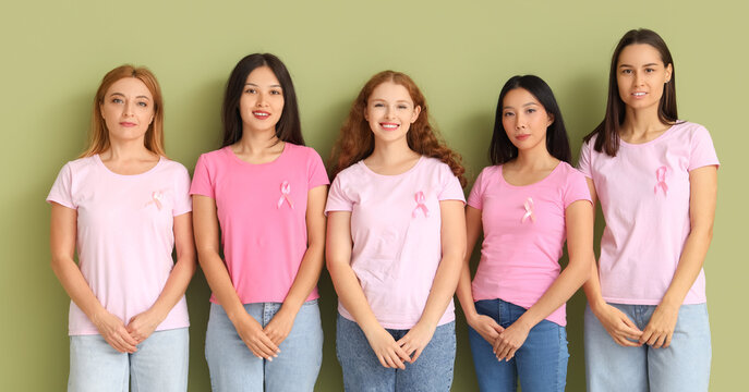 Beautiful women with pink ribbons on green background. Breast cancer awareness concept