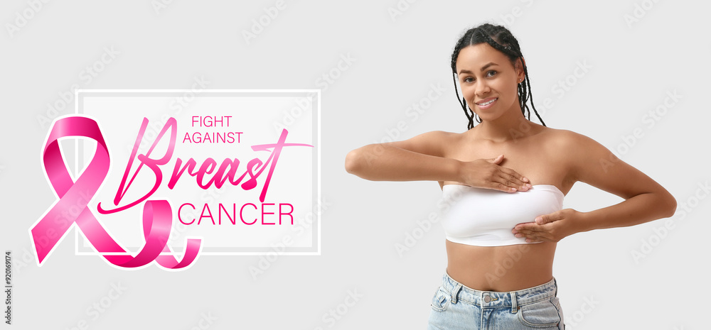 Wall mural Young African-American woman checking her breast on white background. Cancer awareness concept