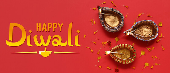 Diya lamps with flower petals on red background. Divaly celebration