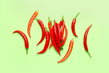 Fresh hot chili peppers on pale green background