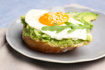 Plate of tasty bruschetta with avocado and egg on table, closeup