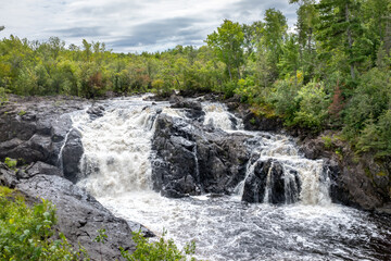 Majestic Kawishiwi Falls Cascading Through Lush Wilderness near Ely, Minnesota - A Serene Landscape of Flowing Waters and Rugged Rocks