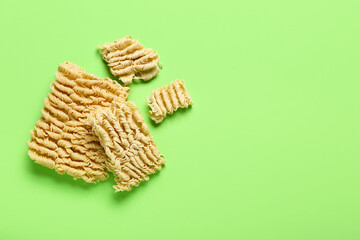 Raw instant noodles on light green background