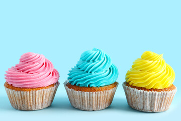 Tasty colorful cupcakes on blue background
