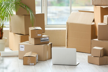 Fototapeta premium Laptop with parcel boxes in room