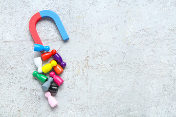 Magnet attracting group of customers on grunge grey background. Marketing concept
