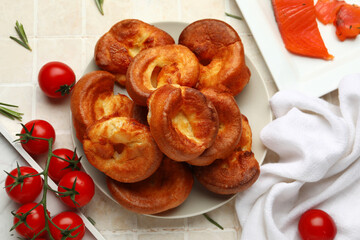 Plate with tasty Yorkshire pudding on light tile background