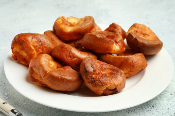 Plate with tasty Yorkshire pudding on light background