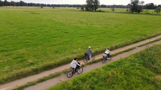 Group of fiends ride bicycles along a field in Straupitz, Germany.