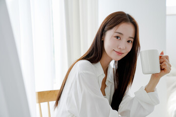 マグカップを持ってリラックスする若い女性