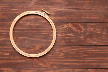 Embroidery hoops on brown wooden background