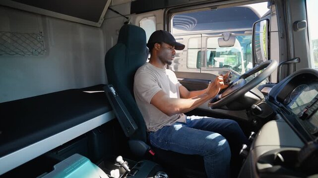 African American truck driver using truck gps navigation to looks the route before leaving