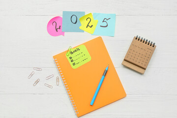 Notebook with to do list and sticky notes on white background. New year goals concept