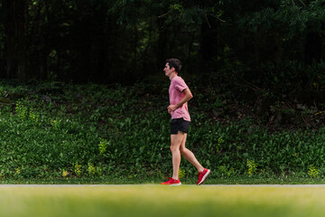 Man running slowly for cardio training outdoors. Fitness life