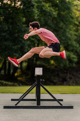 Steeplechase runner training on the athletics track. Vertical