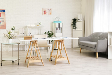 Interior of medical office with table, cooler and sofa