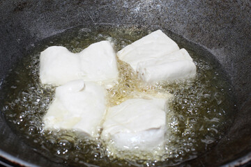 the tofu is being fried in the pan