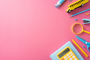 Collection of various school supplies including a bus toy, calculator, and magnifying glass on a...