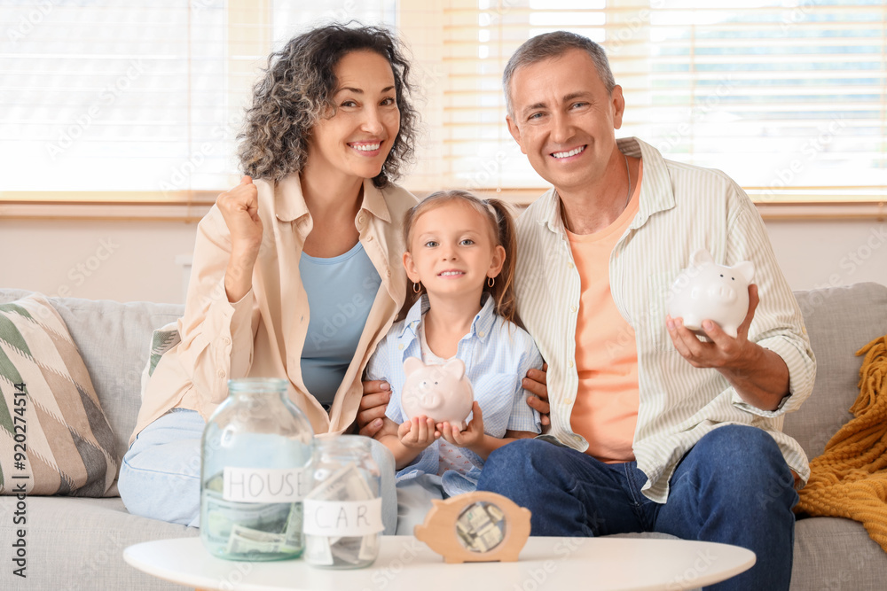 Canvas Prints happy family with money jars and piggy banks sitting on sofa at home