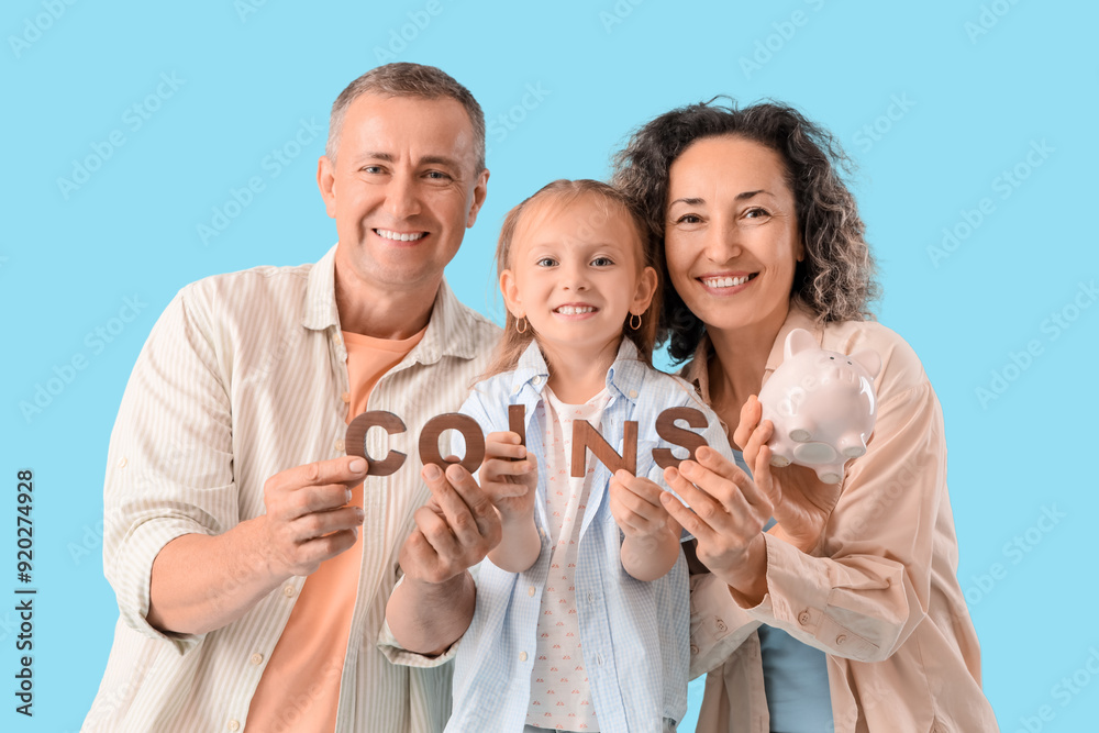 Wall mural Happy family with piggy bank and word COINS on blue background