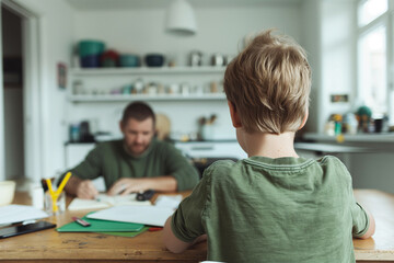 Obraz premium Father and son on the kitchen table doing homework