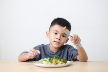 Nutrition healthy eating habits for kids concept. Children do not like to eat vegetables. Little cute boy refuses to eat healthy vegetables.