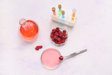 Professional laboratory glassware with raspberries and samples on white background, top view
