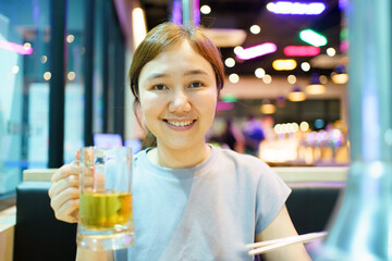 Asian beautiful woman enjoy eating a Korean Bar-B-Q and drinking a beer.