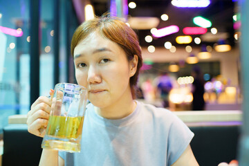 Asian beautiful woman enjoy eating a Korean Bar-B-Q and drinking a beer.