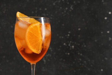 Glass of Aperol spritz cocktail on black background