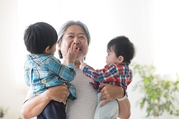 孫を抱っこしてあやすおじいちゃん