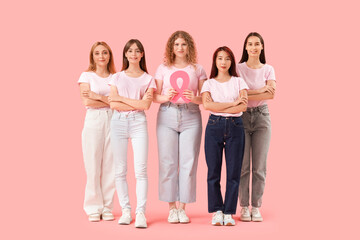 Naklejka premium Beautiful women with pink ribbon on color background. Breast cancer awareness concept